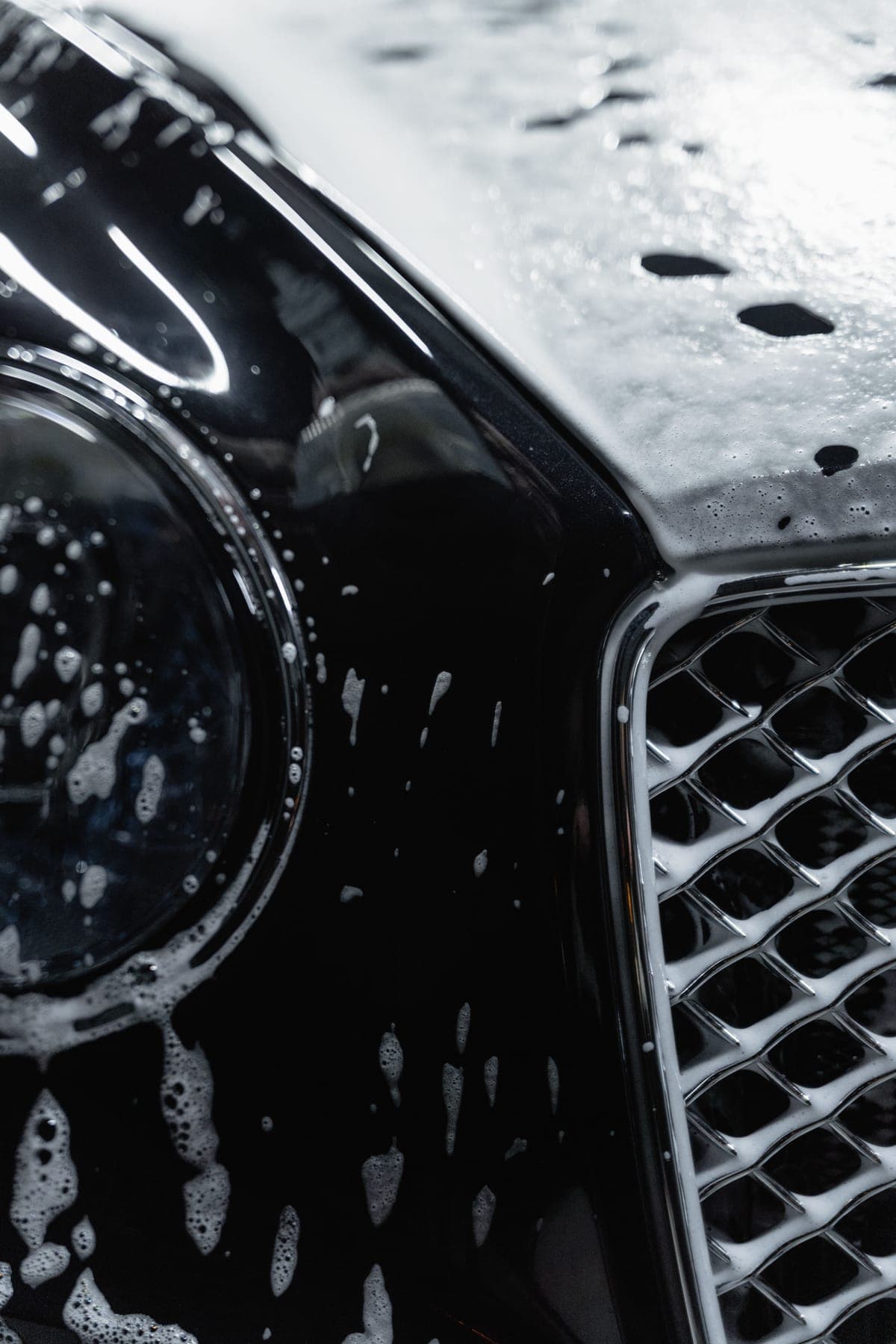 Carrosserie noire recouverte de mousse pendant le lavage